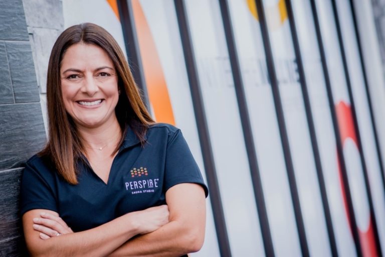 Julie Wordell, pictured in front of signage for Perspire Sauna Studio on Aloma Ave. in Winter Park, Fla.