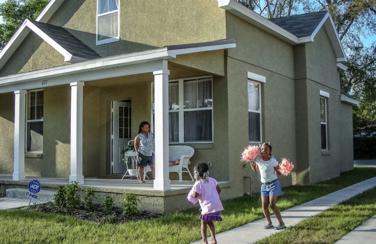 Family pictured playing in front of their house.