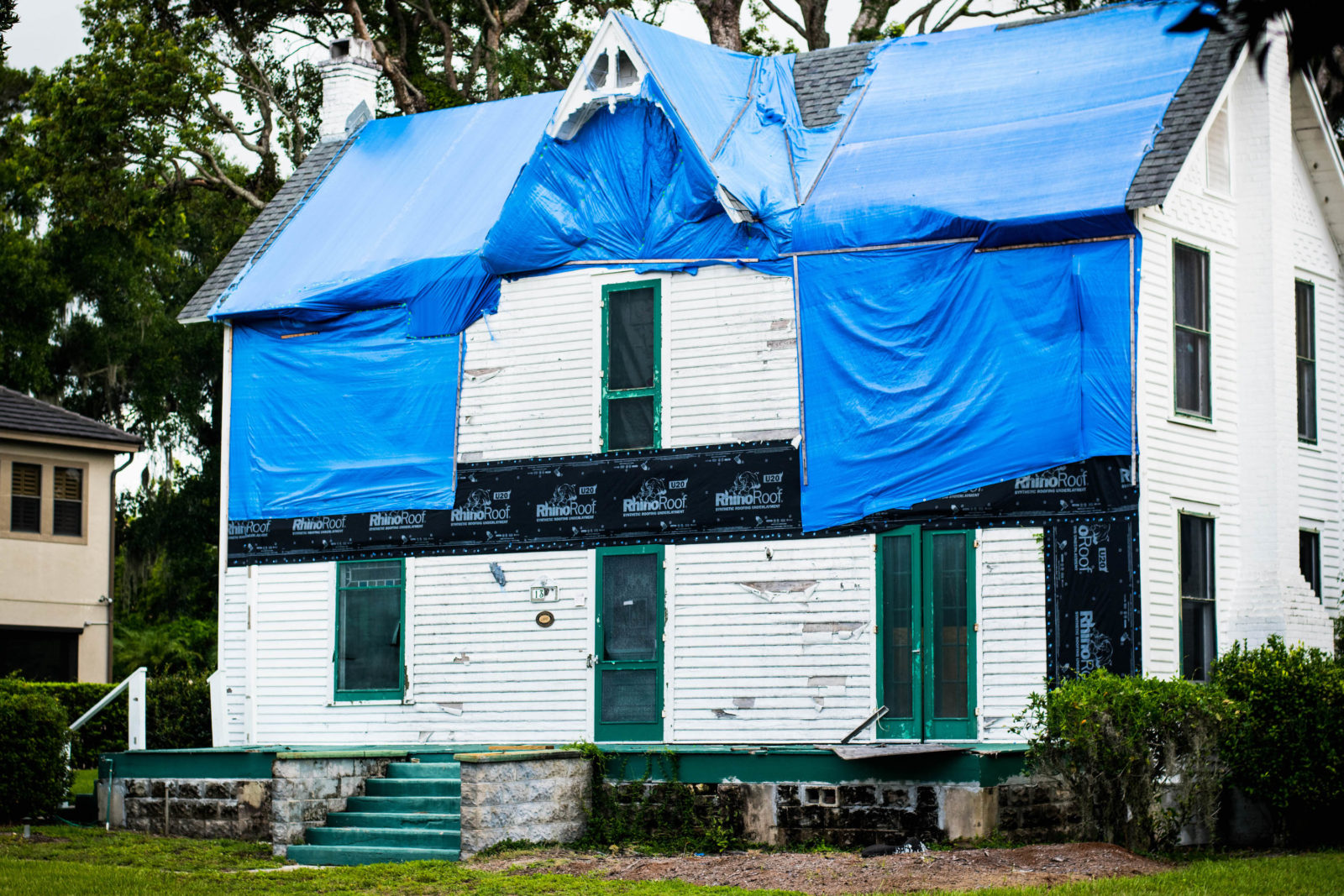 Front facing view of the Waddell House covered in blue tarps.