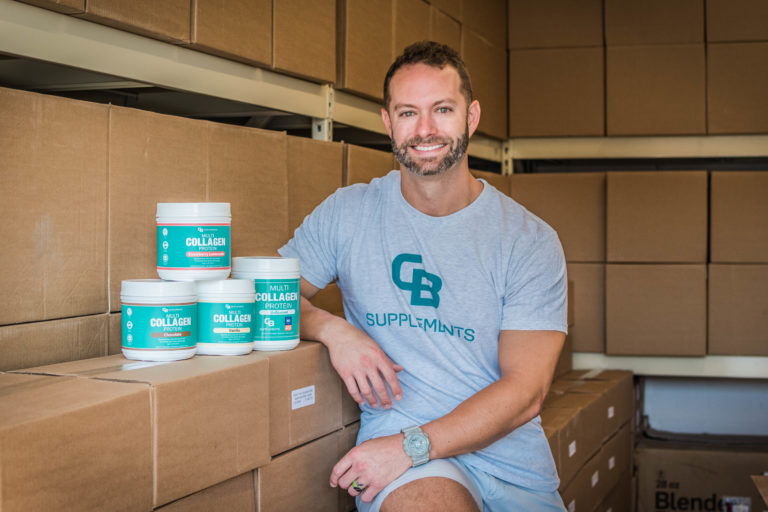 Charlie Bailes sits on stacked boxes with his product.