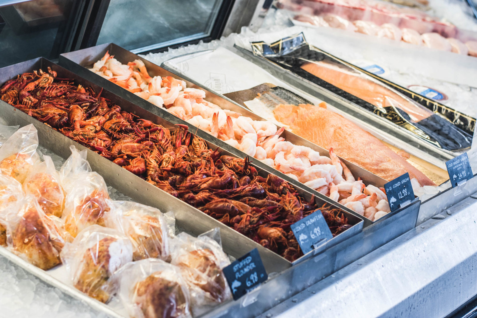Various seafoods in a refrigerated glass display case. 