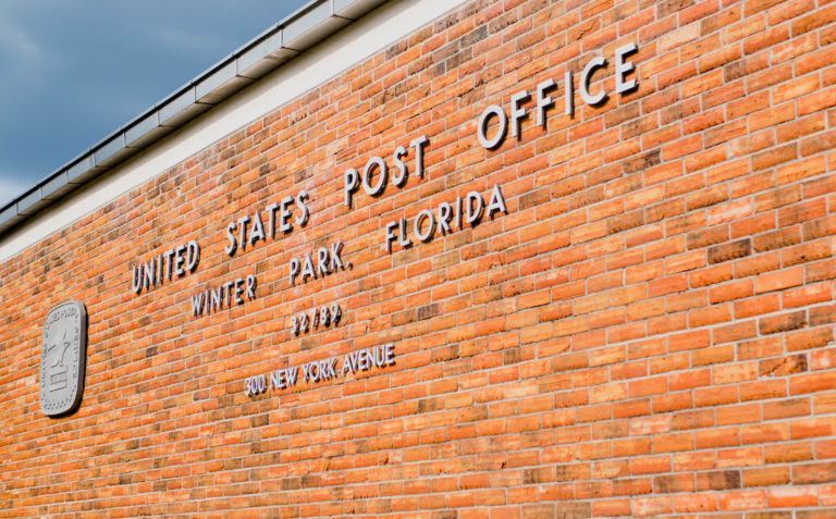 Winter Park Post Office signage on brick wall of building.
