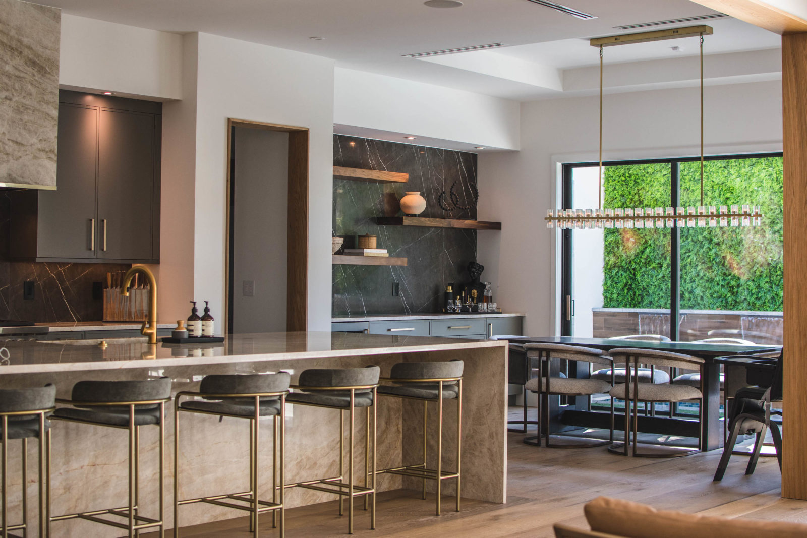 Large kitchen featuring dark cabinetry and gold fixtures.