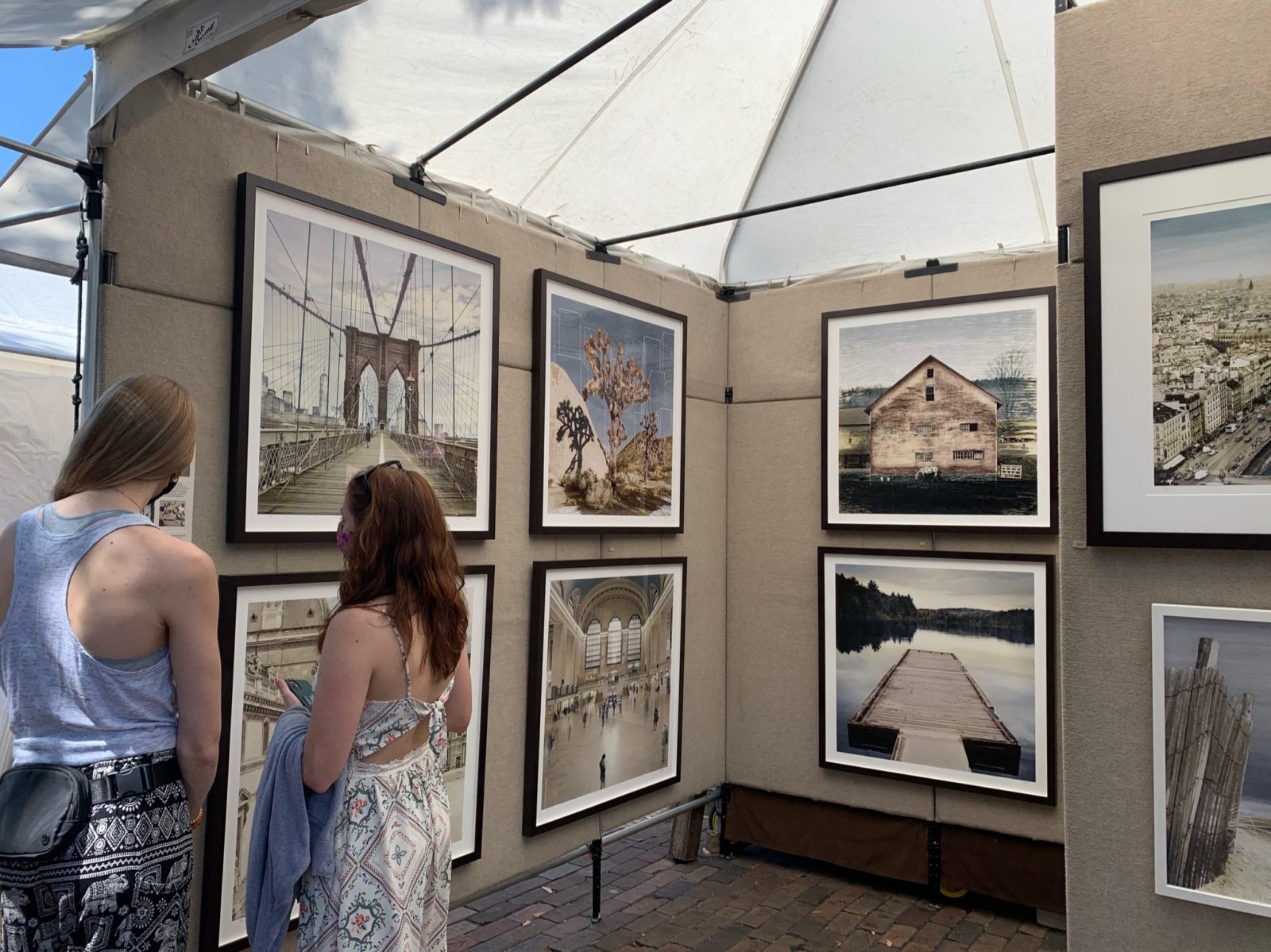 Beige booth shows photography in white and black frames of cities and bridges.