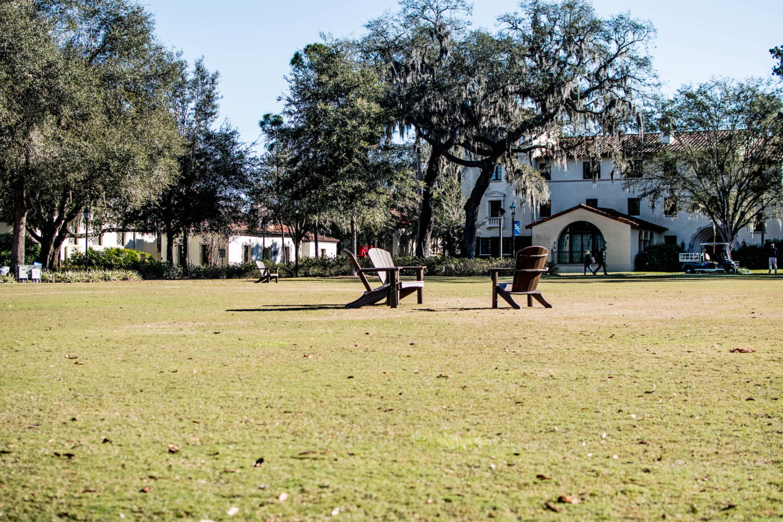 Photo pictures green space with chairs in front of the Rollins College campus.