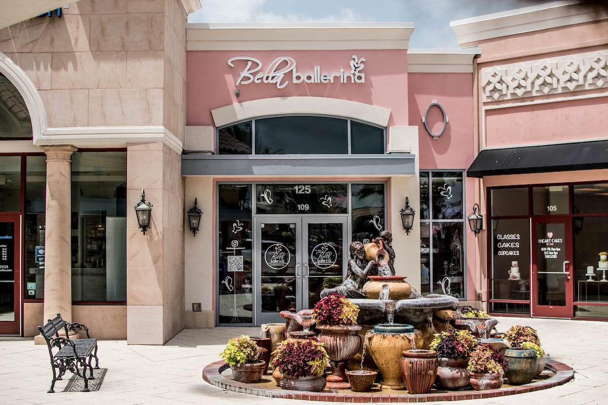 Light pink building with brown fountain and white sidewalk