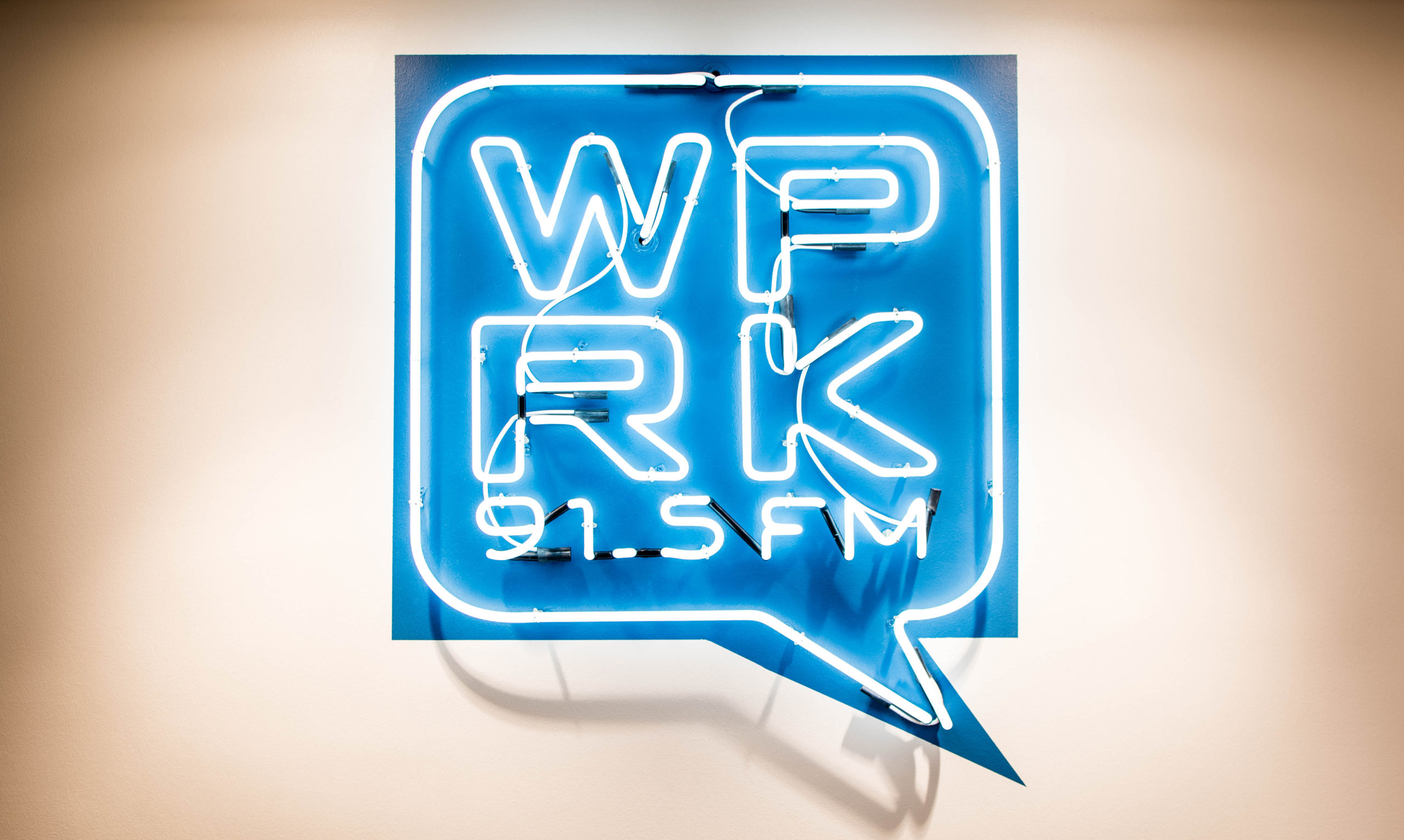 Blue neon sign that reads WPRK 91.5 FM.